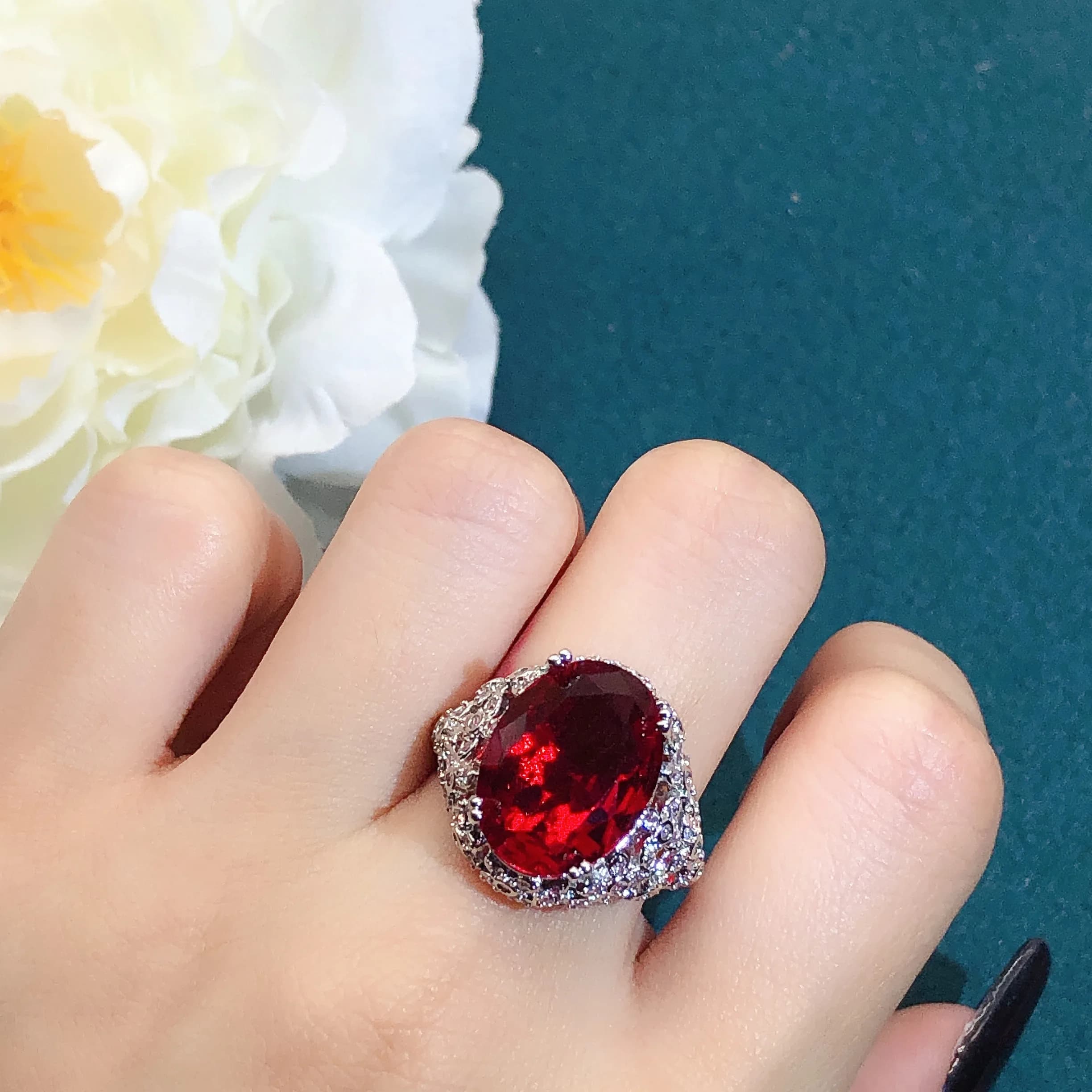 Anello con rubino rosso a forma di uovo di piccione per donna, design di alta gamma con diamanti laterali, accessorio di gioielleria alla moda.