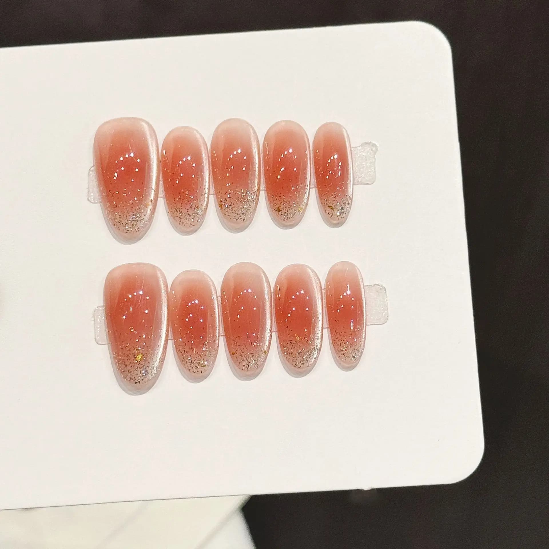 10 pieces of handmade fake nails in french style, light orange color, with gold powder decorations, short oval shape.