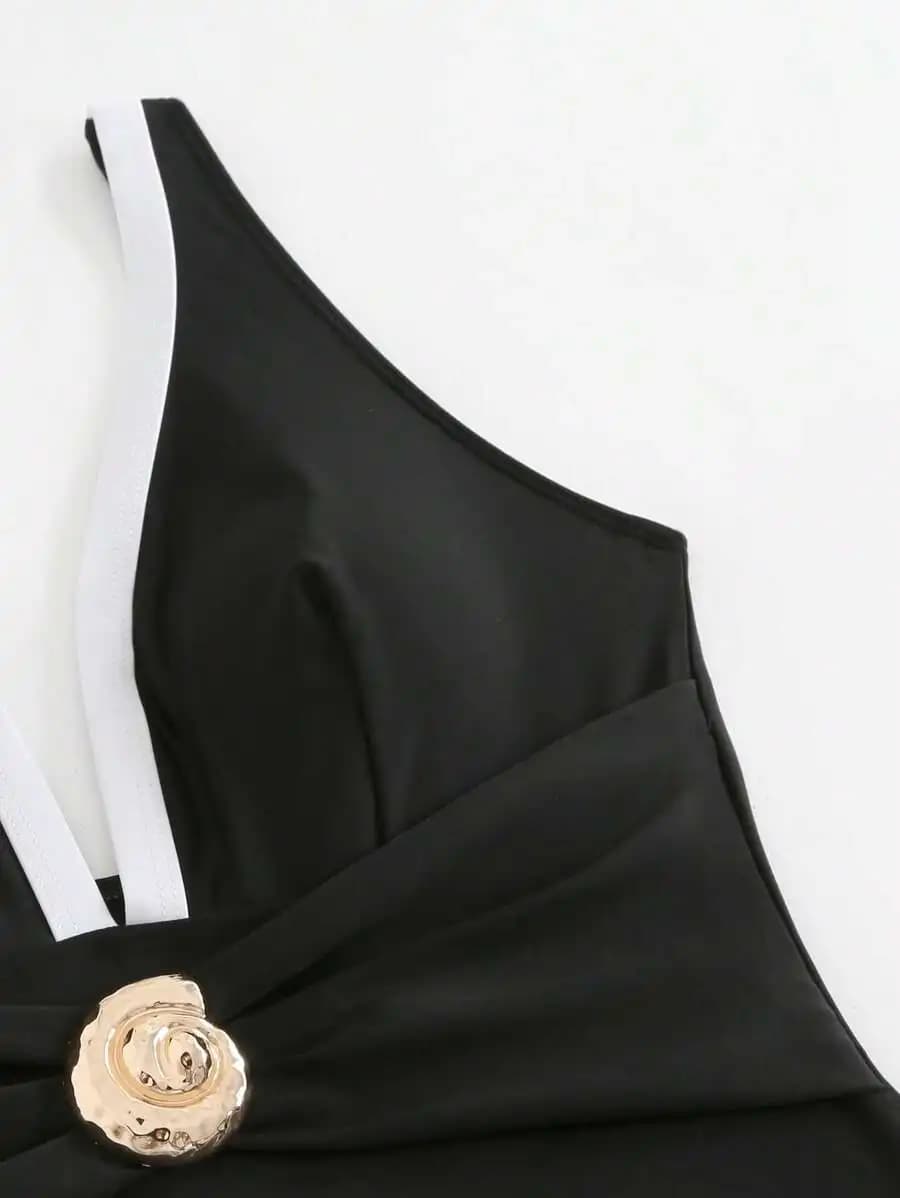 Costume da bagno da donna con scollo a V profondo in bianco e nero a contrasto, monospalla, con decorazioni in metallo e minigonna con spacco