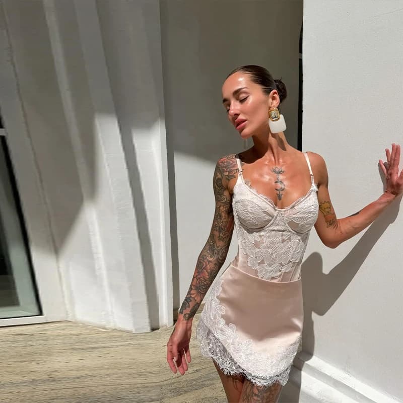 Completo due pezzi in raso rosa cipria con pizzo per donna, top corsetto con lacci sul retro e minigonna, outfit Y2K per feste estive e discoteche.