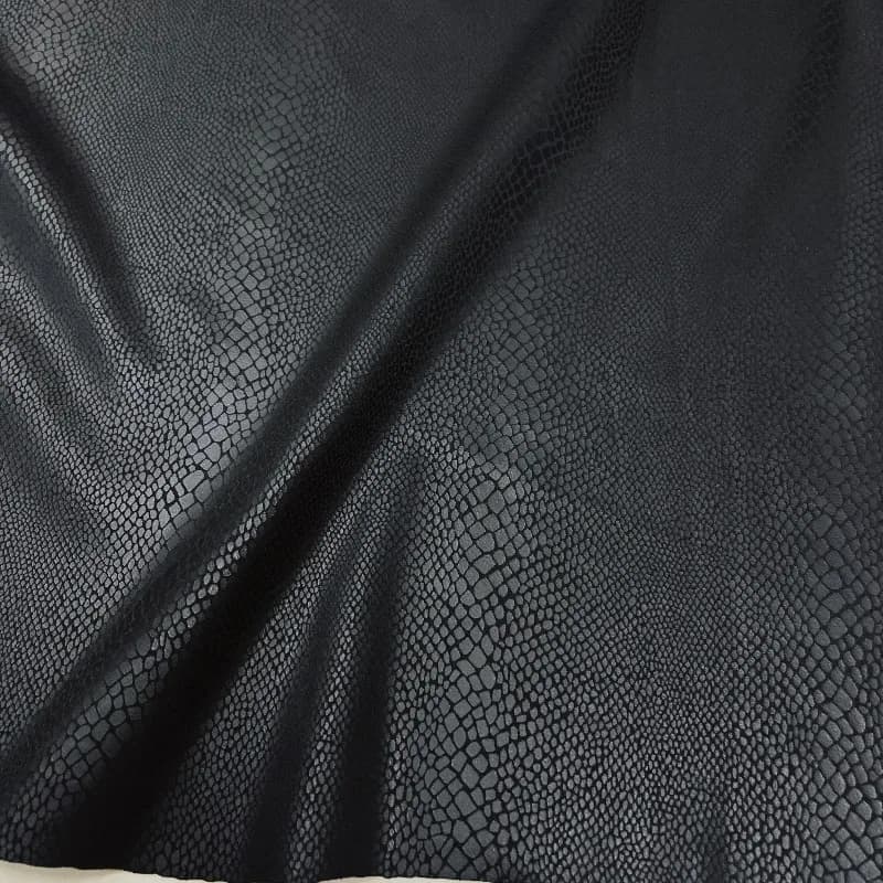 Tessuto in PU effetto pelle con texture goffrata a motivo pitone nero, dal design raffinato, per gilet, pantaloni e giacche in pelle.