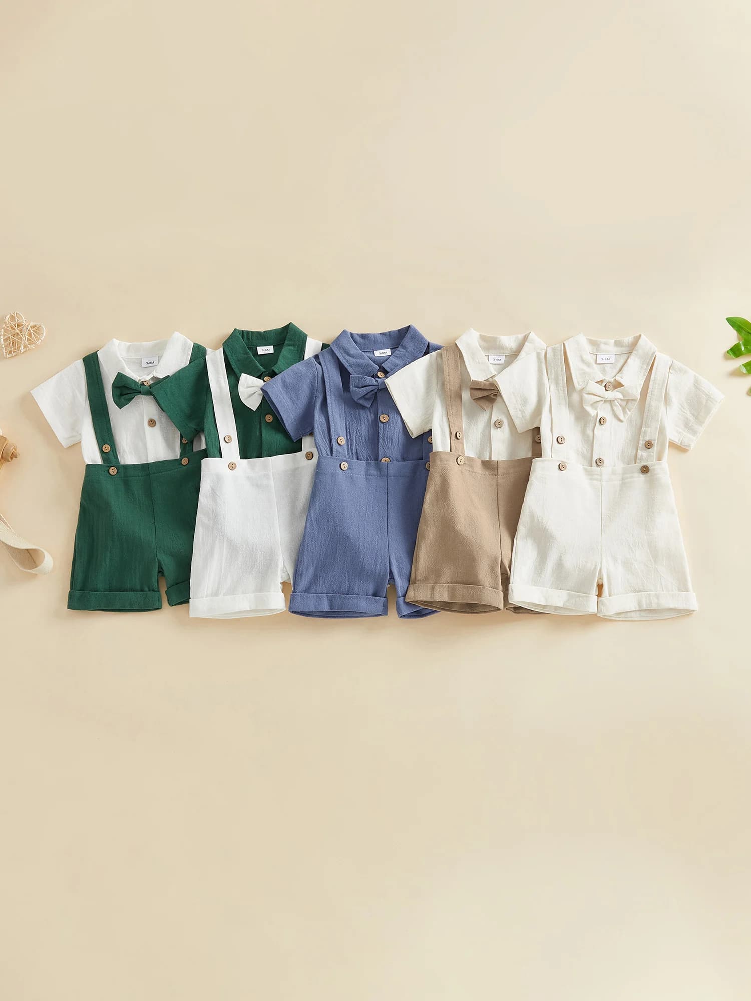 Adorabili completi estivi per neonati. Elegante pagliaccetto a maniche corte con papillon e pantaloncini con bretelle. Set da 2 pezzi per una moda