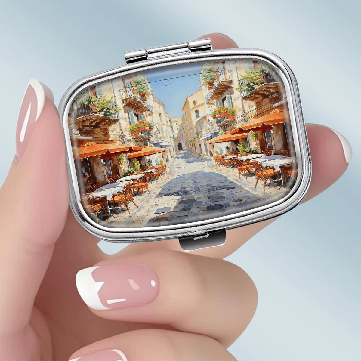 1PC A portable square metal pill box featuring a bright and relaxed scene of a southern European small town street, with a 2-compartment design, perfect for elegantly storing your medication or supplements. It is very suitable for sorting vitamins and storing small items.