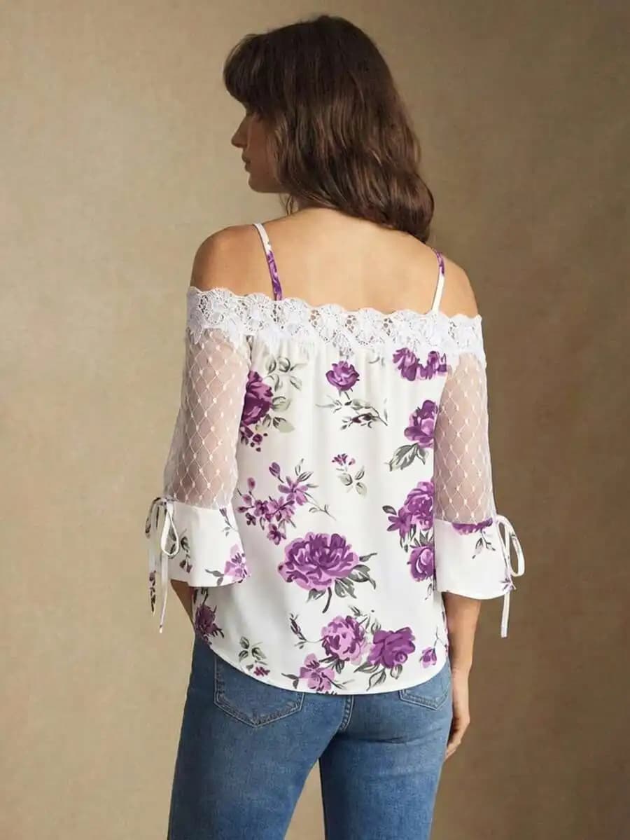 Camicetta viola con stampa floreale, spalle scoperte, inserti in pizzo e maniche in rete con fiocco sul polsino