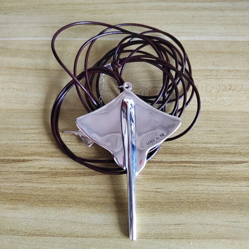 Un ciondolo a forma di pesciolino marino, con un design personalizzato e una collana con cordino in pelle pregiata.