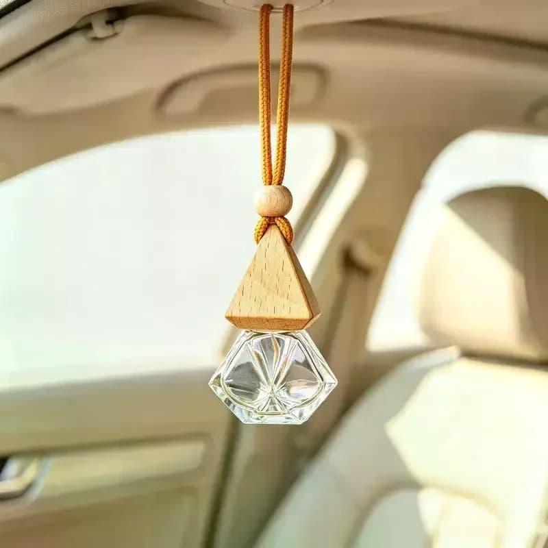 A car diffuser bottle with a natural wooden cover and transparent glass, hanging empty, used for DIY car interior decoration