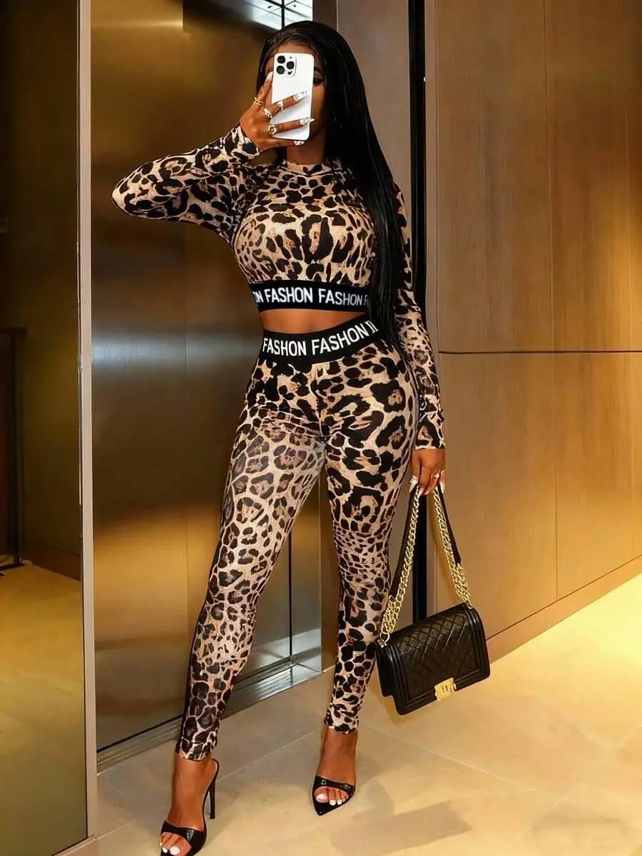 Women's suit with two-piece print, belt with 'FASHION' writing, short sleeved top and leggings.