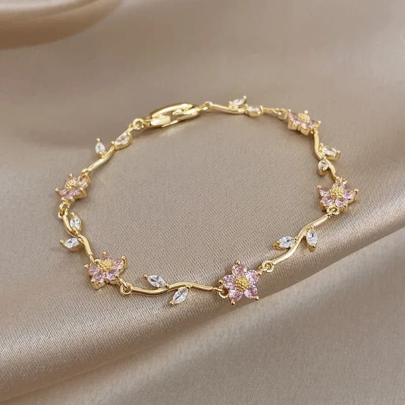 Delicato braccialetto con ciondolo a forma di fiore in oro. Fiori rosa, zirconi marquise, lucidati