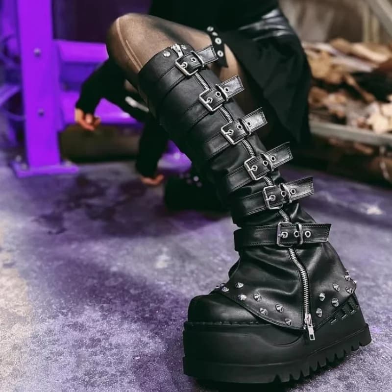 Top black punk boots with thick sole and covered legs, gothic boots with decorative belt, leather shoes and covered legs