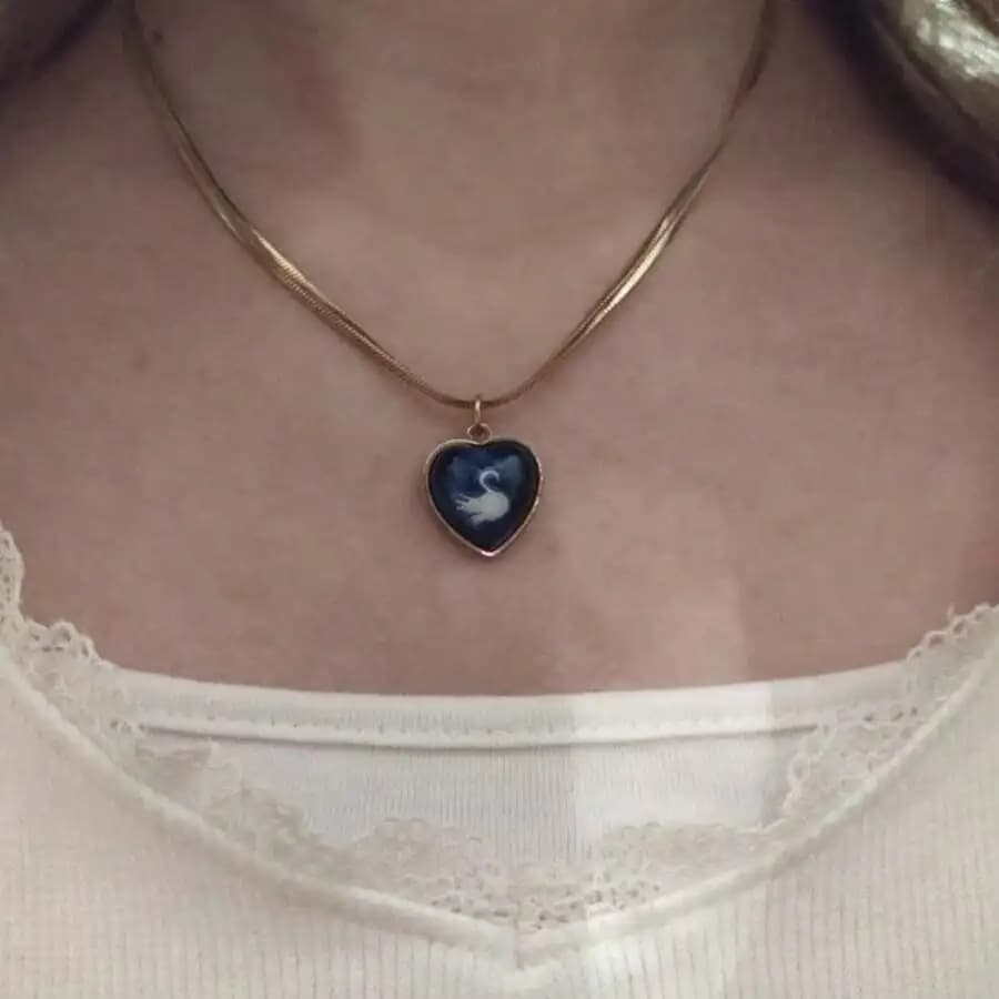Collana con ciondolo a forma di cuore con silhouette di cigno su resina blu, montatura color argento