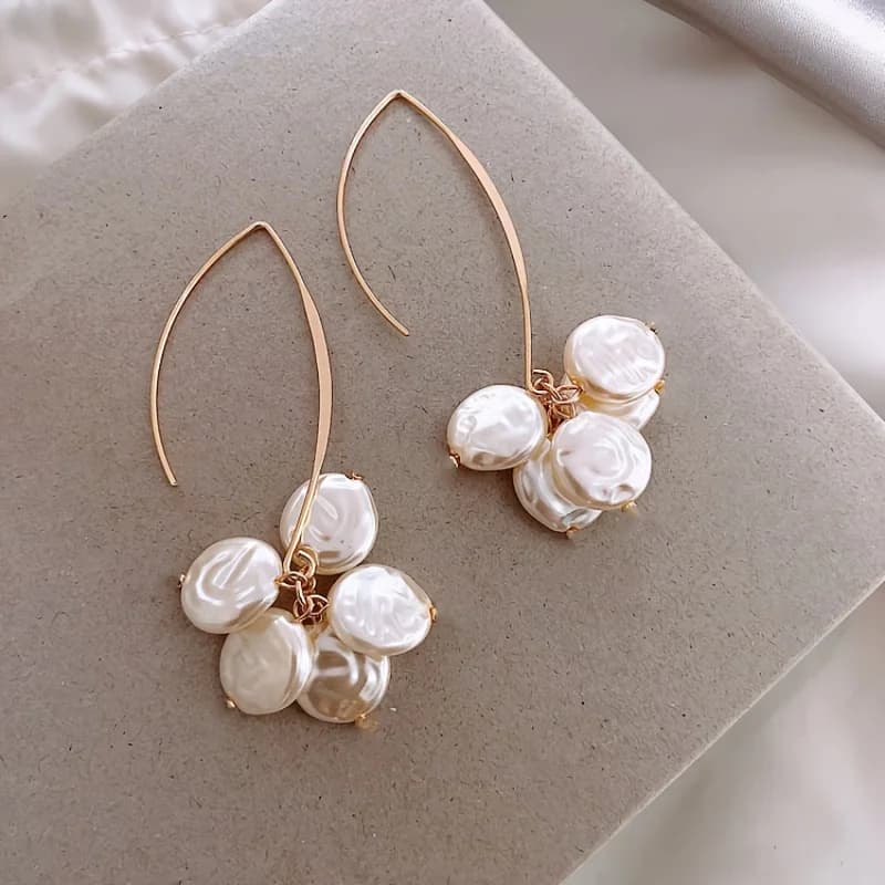 Un paio di orecchini semplici ed eleganti da donna, orecchini pendenti con perle finte, perfetti per il pendolarismo quotidiano e l'abbigliamento casual