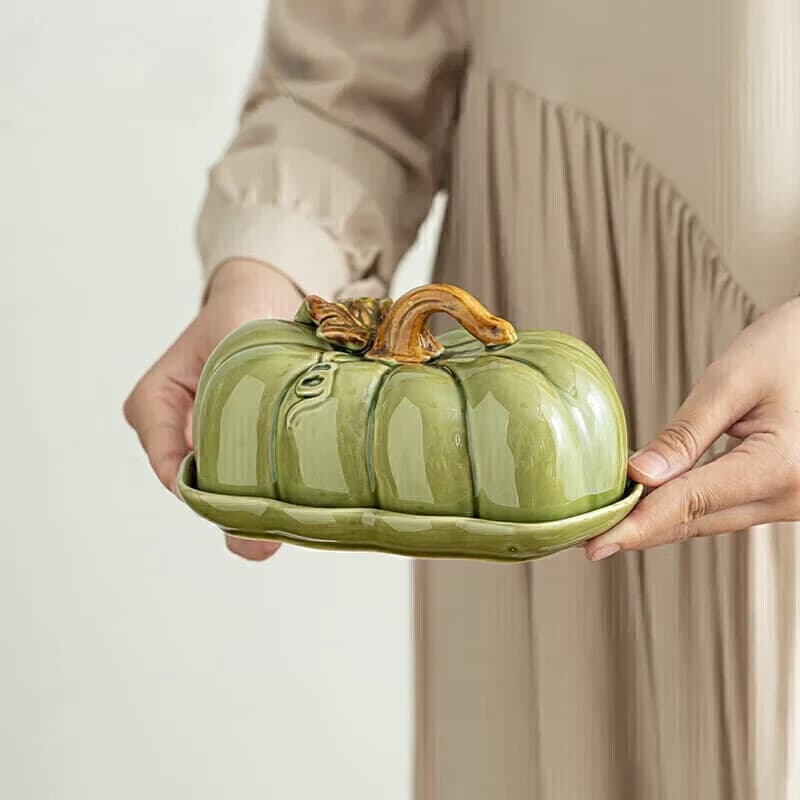 Torta di pane a forma di zucca in ceramica e piatto di frutta secca, caramelle, burro, snack, vassoio, stoviglie per la casa