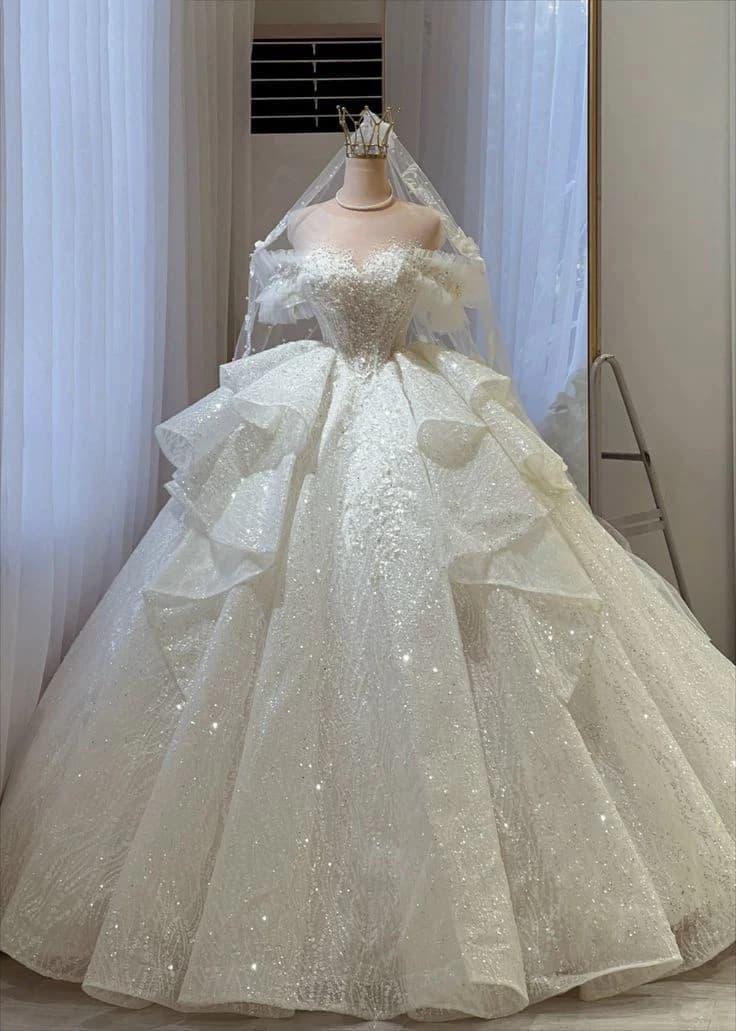 Abito da ballo elegante e scintillante con volant, spalle scoperte, pizzo ricamato con perline e lussuoso abito da sposa personalizzato