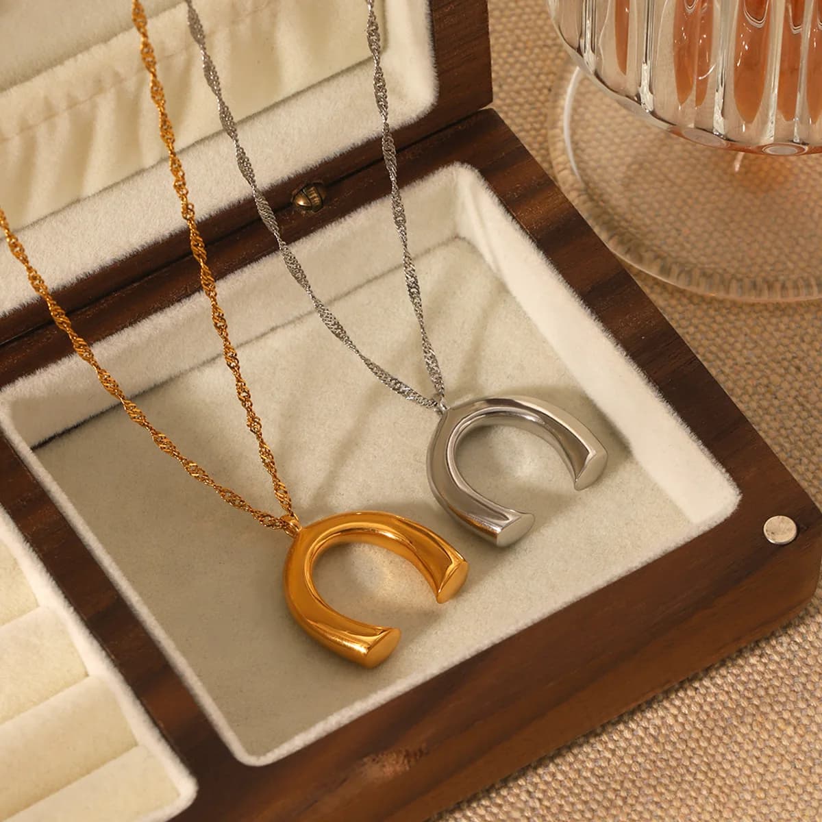 Collana con ciondolo a forma di ferro di cavallo a U con catena effetto onda d'acqua per donna, catena da collo in acciaio al titanio alla moda e unica.