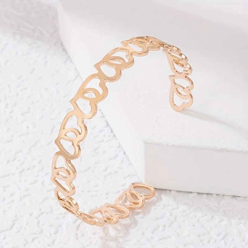 Un elegante bracciale a catena dorato traforato da donna - gioiello da mano femminile in lega semplice e multifunzionale