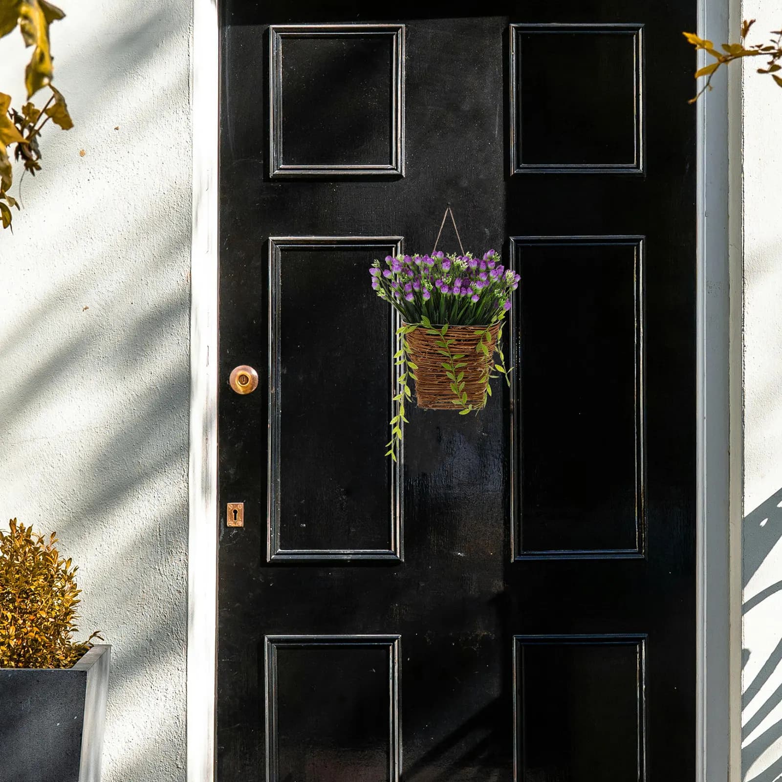Wall hanging basket in braided wicker, with artificial purple floral composition, spring/outdoor wreath