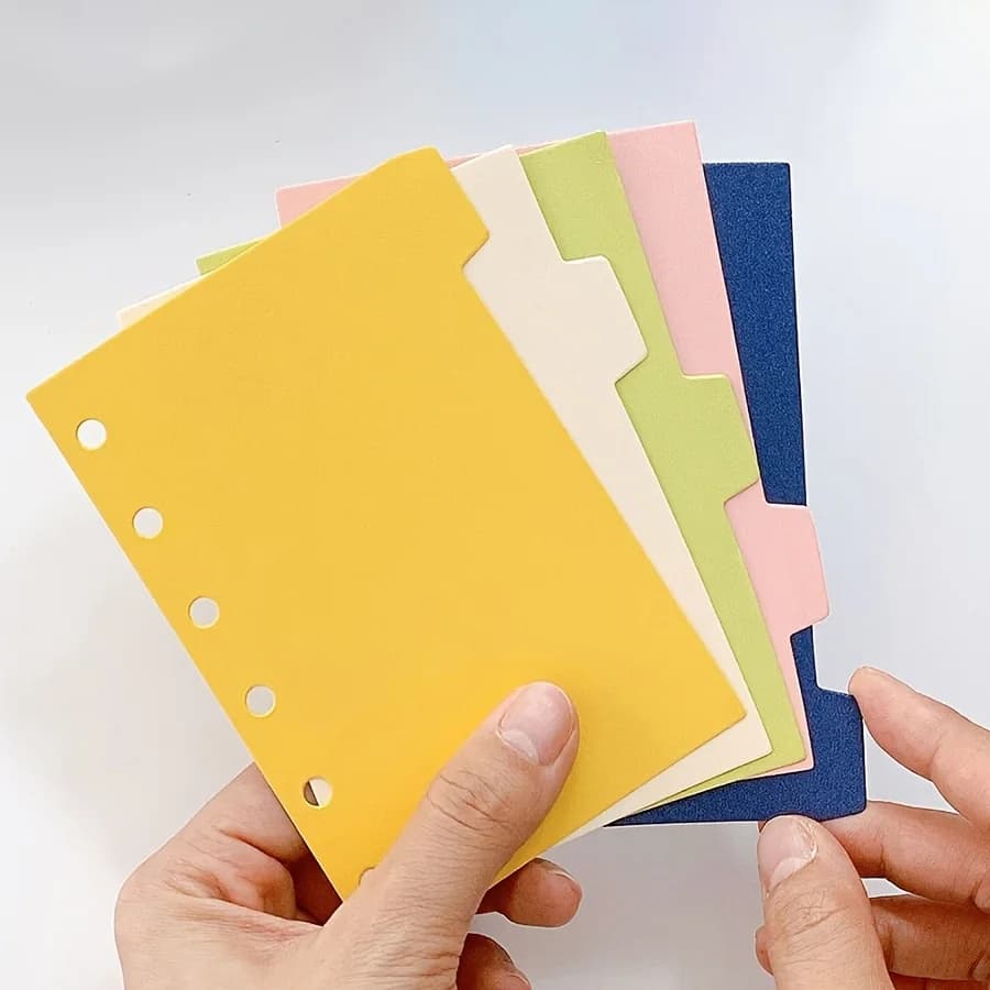 5 pagine divisorie per indice, raccoglitore ad anelli a 6 fori, pagine divisorie per quaderni A7, etichette di classificazione, agenda.