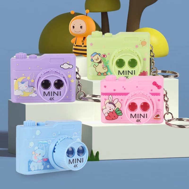 Mini macchina da gioco per proiezione di fotocamera per cartoni animati Doppia luce Proiettore di immagini di movimento Fotocamera appesa Decorazione Portachiavi Ciondolo Giocattoli