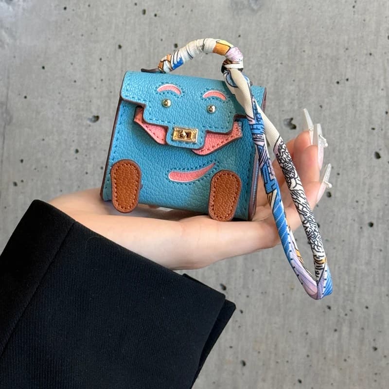 2026 - Custodia per auricolari in pelle PU fatta a mano con ciondolo decorativo a forma di mini borsa, compatibile con Airpods 4, Pro2, 3, 2 e 1, mini portafoglio con laccetto