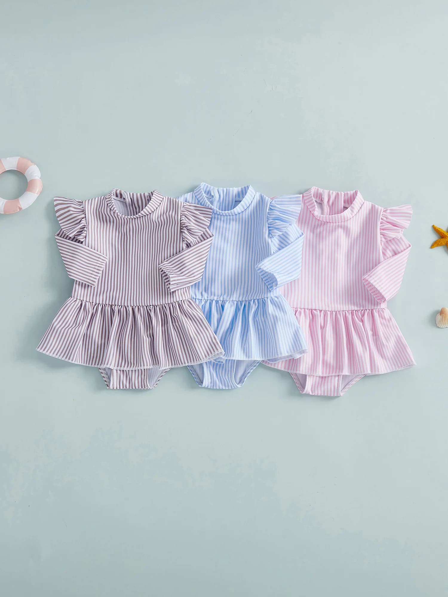 Adorabile costume da bagno per bambina con graziose maniche con volant e colletto rialzato. Elegante protezione antigraffio con gonna con stampa a righe