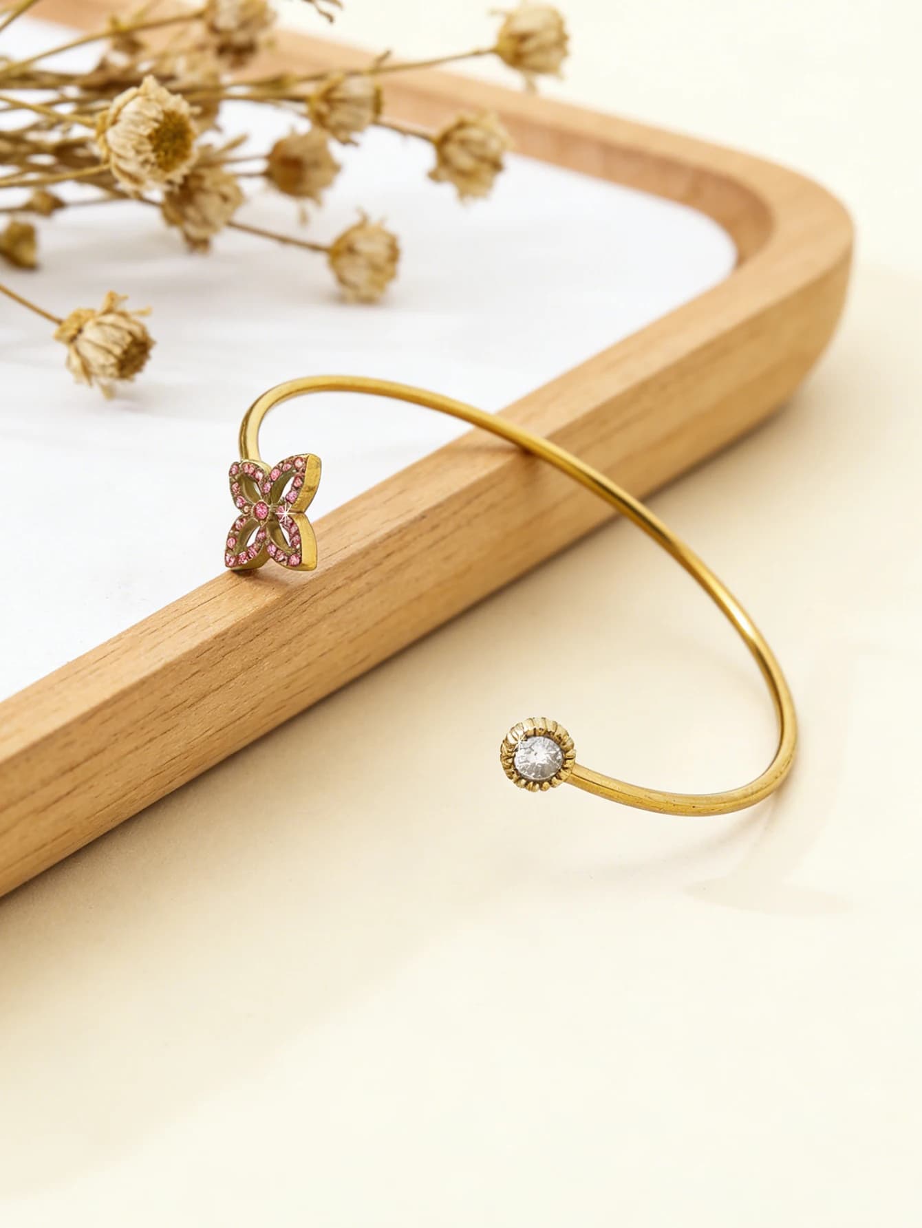 A delicate, fresh and refined style bracelet made of 18K gold plated stainless steel with diamonds set in the shape of a quadrifoil, open.