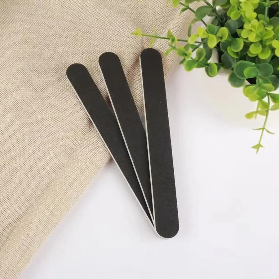 Black double-sided straight nail file with red core and sandpaper for manicure polishing and nail shaping at home or salon