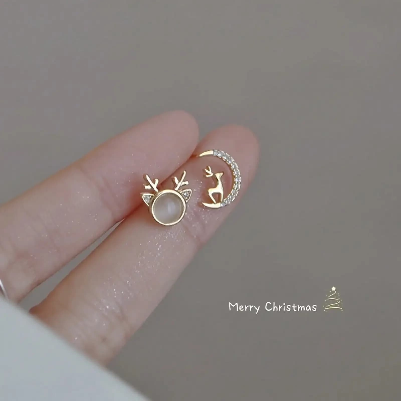 Un paio di eleganti orecchini asimmetrici con renne natalizie e luna, con zirconi, pietre sintetiche, lega di zinco, argento sterling 925