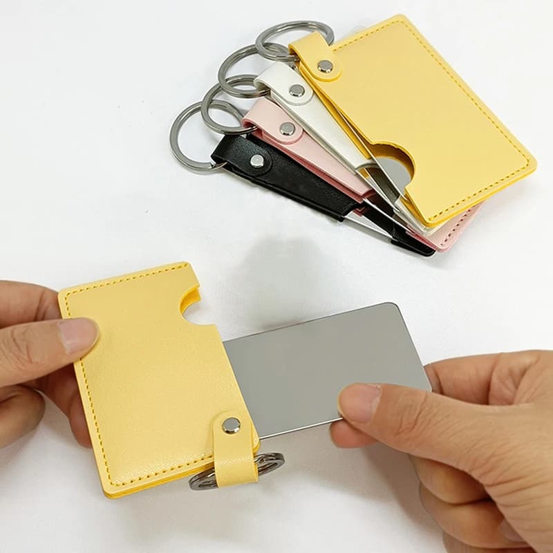 Specchio cosmetico ultrasottile infrangibile in acciaio inossidabile con portachiavi portatile con custodia in pelle PU tascabile per il trucco dello specchio della carta
